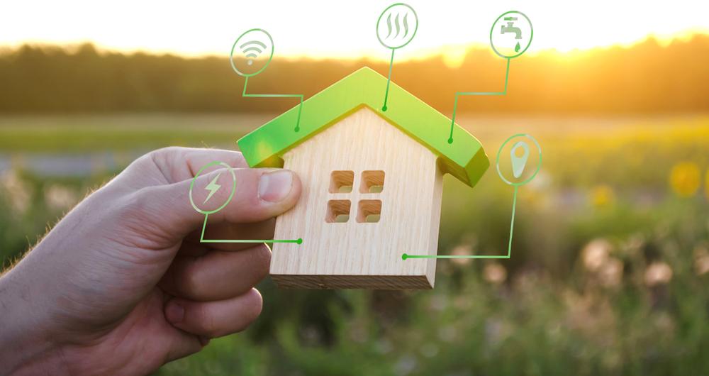 Hand holding wooden house with energy icons to symbolize energy code costs